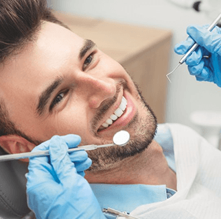 Patient smiling at emergency dentist during checkup