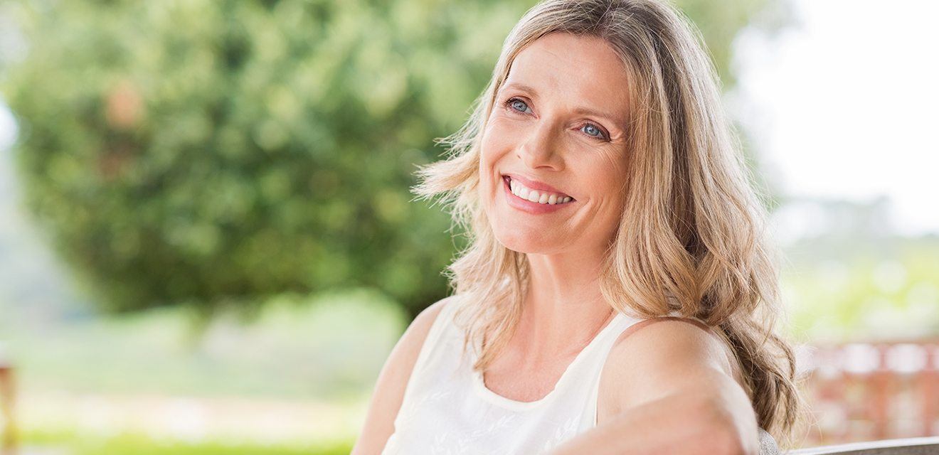 woman smiling outside on bench