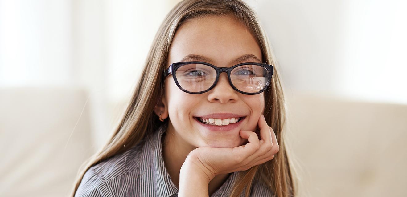 young girl with glasses smiling