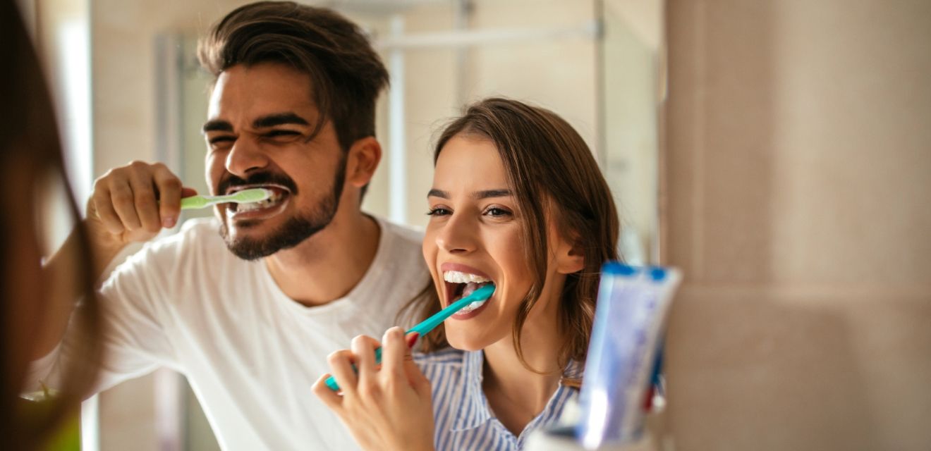 man and woman brushing teeth