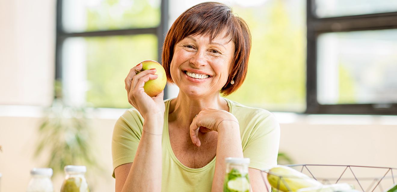 woman holding apple and smiling