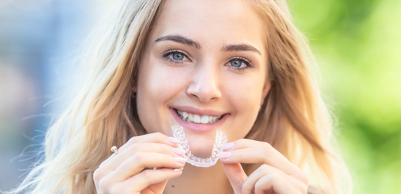 woman holding invisalign