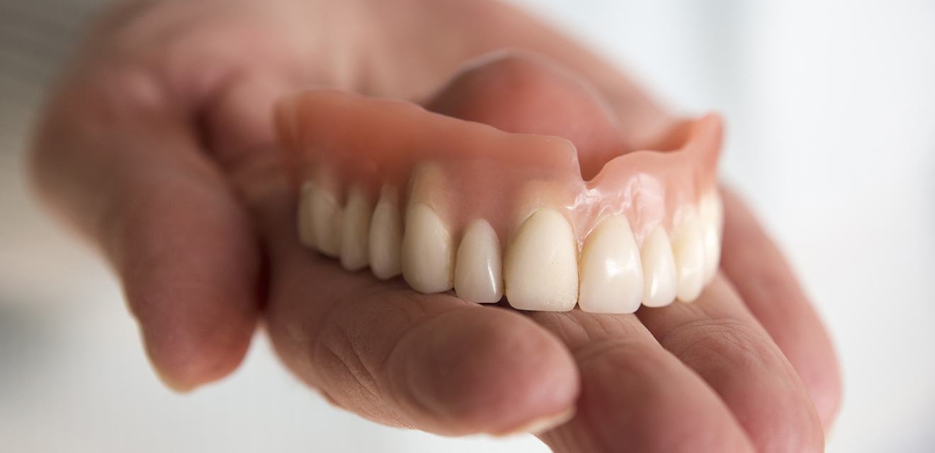 hand holding dentures