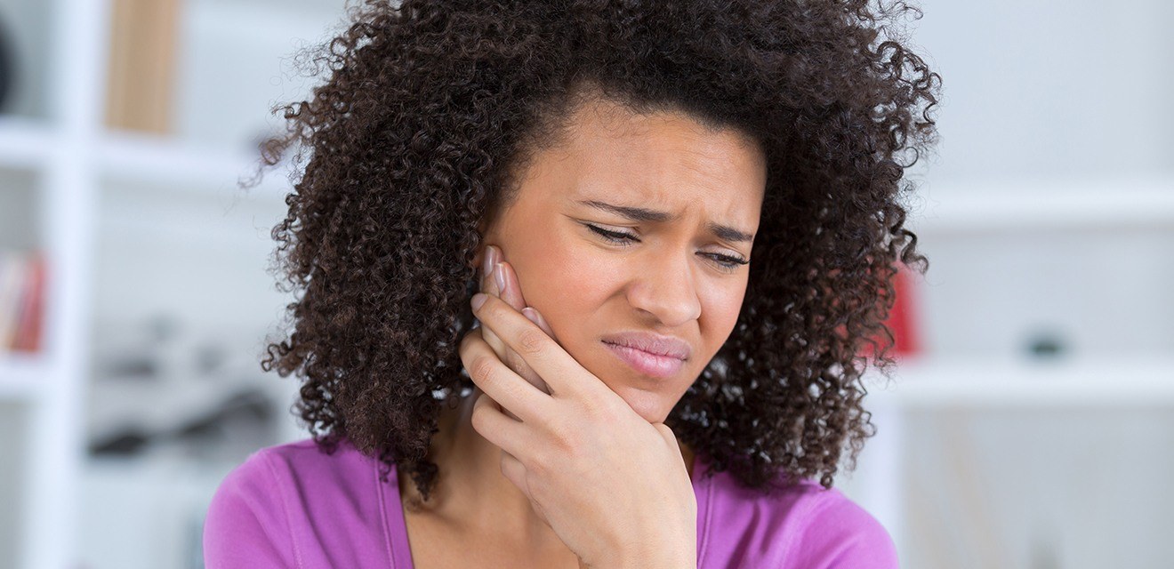 woman holding jaw in pain