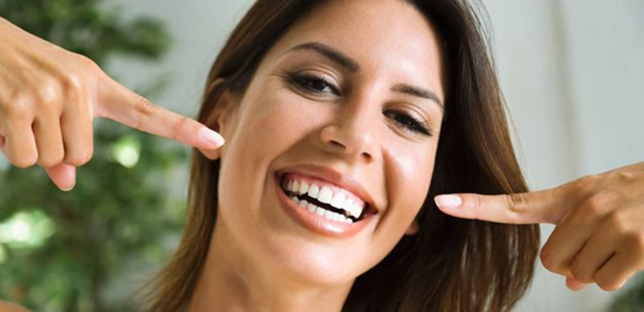 Woman smiling after teeth whitening in Denver