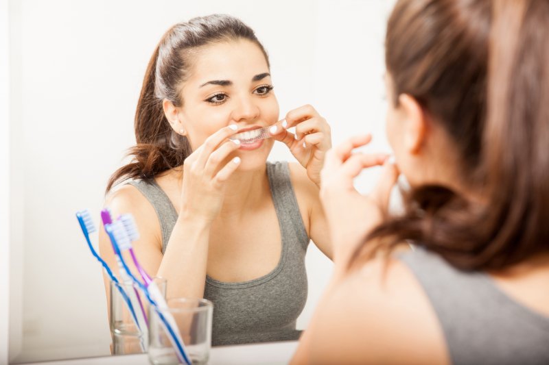 young woman using whitening strips