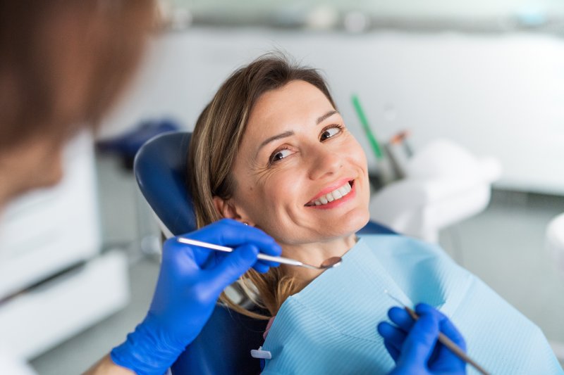 A smiling woman receiving a dental checkup from her dentist